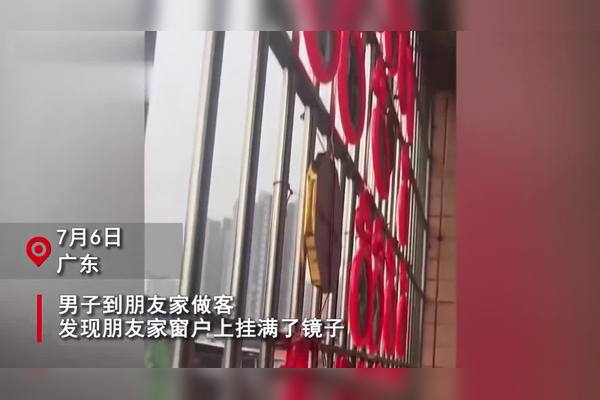 一条狭窄的老城巷子,两侧旧楼阳台挂满衣物,几盆盛开的红色月季从铁栏杆里探出头来